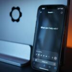 Smartphone displaying an AI chatbot interface in a dimly lit room, representing AI companions, digital relationships and the commercialization of human connection.