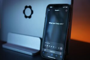 Smartphone displaying an AI chatbot interface in a dimly lit room, representing AI companions, digital relationships and the commercialization of human connection.