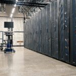Rows of AI server racks inside a modern hyperscale data center powering artificial intelligence infrastructure.