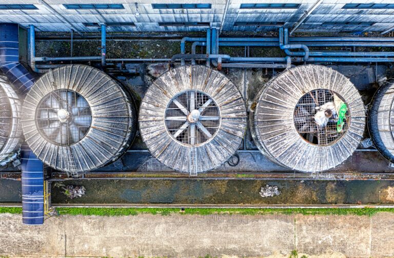 Large industrial cooling fans on a commercial facility as economies expand cooling infrastructure to cope with rising temperatures.