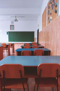 An empty classroom with rows of desks and chairs, symbolizing declining birth rates, aging populations, and shrinking student enrollment.