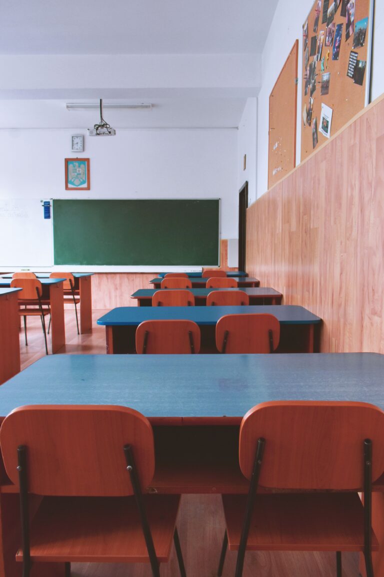 An empty classroom with rows of desks and chairs, symbolizing declining birth rates, aging populations, and shrinking student enrollment.