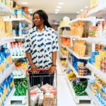 Shopper pushing a cart through a grocery store as food companies assess changing consumer spending linked to GLP-1 weight-loss medications.
