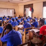 Students taking an examination in a classroom as authorities investigate exam-leak networks involving digital platforms and physical distribution channels.