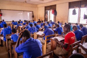 Students taking an examination in a classroom as authorities investigate exam-leak networks involving digital platforms and physical distribution channels.