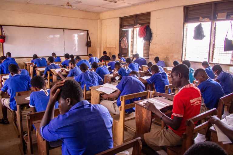 Students taking an examination in a classroom as authorities investigate exam-leak networks involving digital platforms and physical distribution channels.