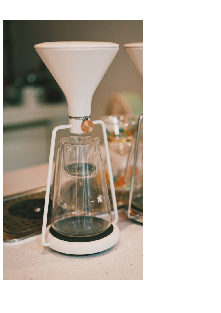 A white funnel narrowing into a glass vessel, symbolizing abundant information being filtered into scarce human attention in the AI economy.