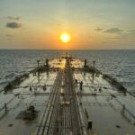 Oil tanker at sea during sunset as markets react to the reopening of the Strait of Hormuz following the U.S.-Iran ceasefire.