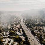 Aerial view of a California suburban community with a major highway, illustrating how climate risk and insurance availability are reshaping housing finance and mortgage markets.