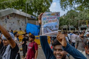 Protester at the CJP protest holds up a handwritten sign referencing the Delhi Metro shutdown during the demonstration