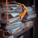 Close-up of stacked, weathered paper files and manila folders symbolizing the ignored warnings in the UK grooming gangs scandal.