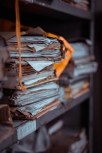 Close-up of stacked, weathered paper files and manila folders symbolizing the ignored warnings in the UK grooming gangs scandal.