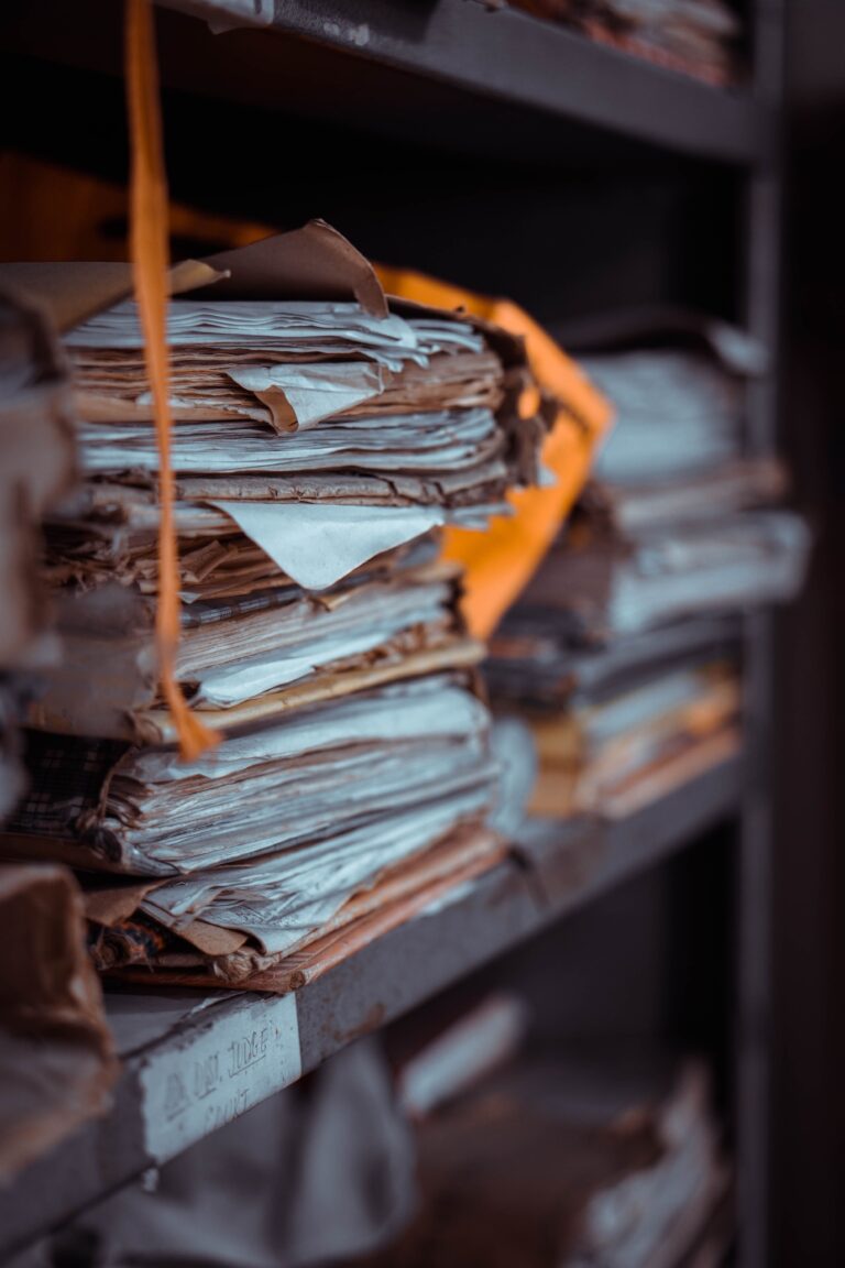 Close-up of stacked, weathered paper files and manila folders symbolizing the ignored warnings in the UK grooming gangs scandal.