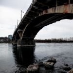 Aging bridge over a river showing signs of wear and long-term infrastructure maintenance needs