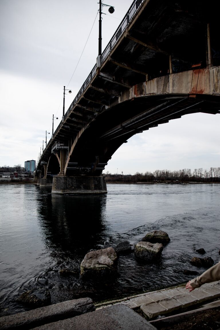 Aging bridge over a river showing signs of wear and long-term infrastructure maintenance needs