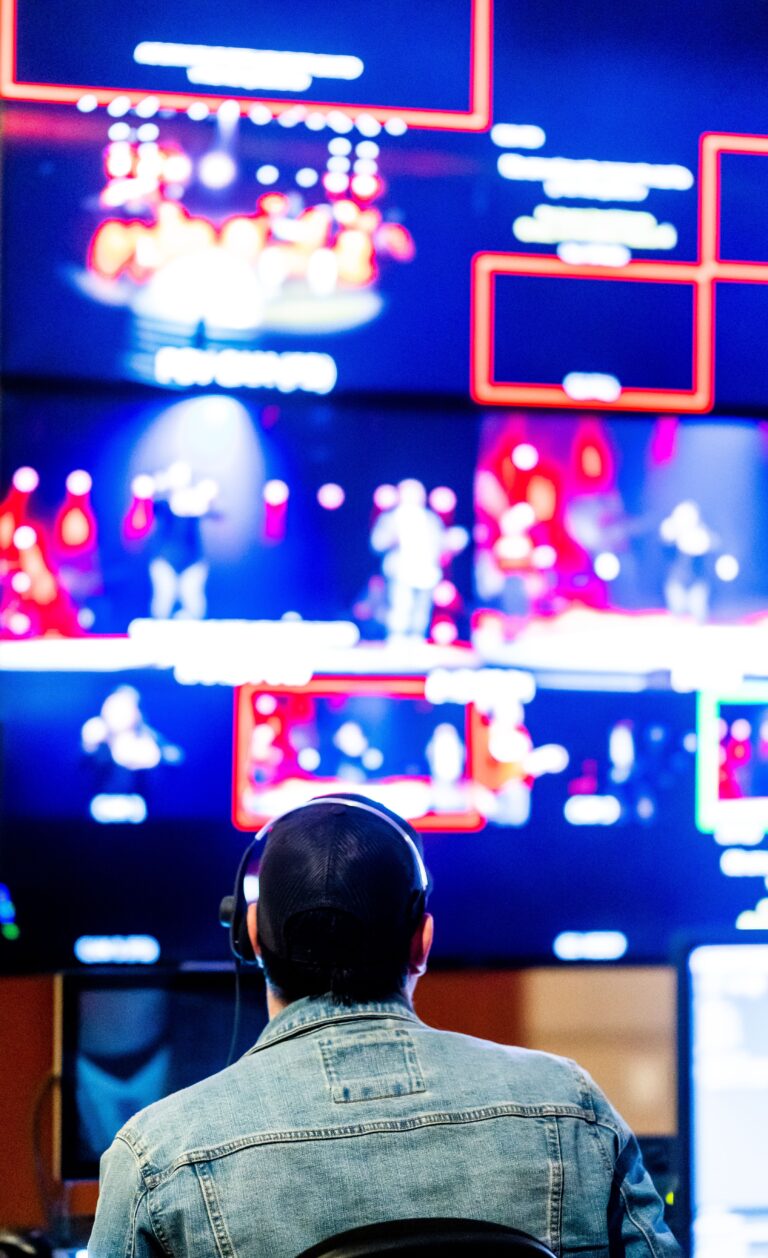 Person sitting in front of multiple glowing digital screens representing the attention economy and endless online content