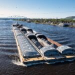 Large cargo barge carrying goods along a major river