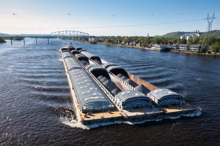 Large cargo barge carrying goods along a major river