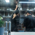 Workers preparing food in a commercial kitchen for delivery