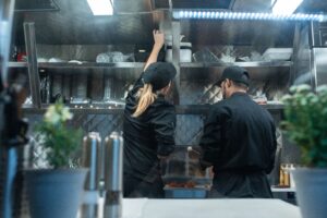 Workers preparing food in a commercial kitchen for delivery