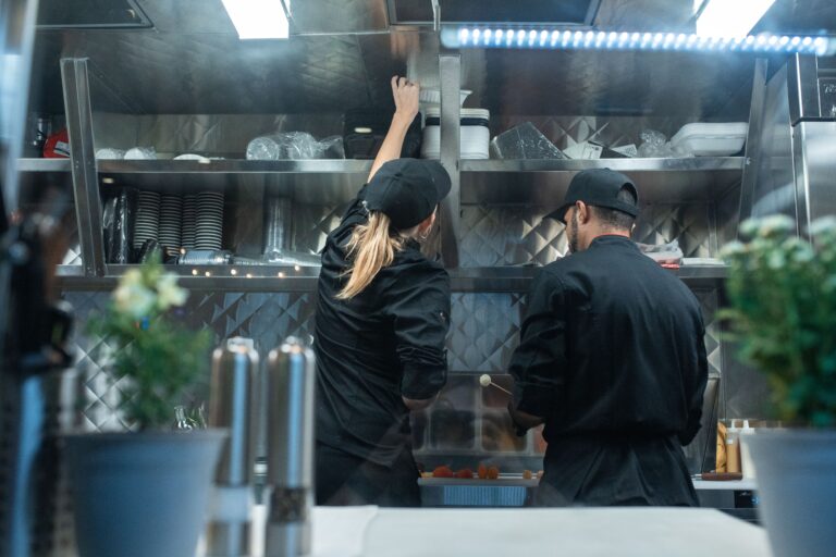 Workers preparing food in a commercial kitchen for delivery