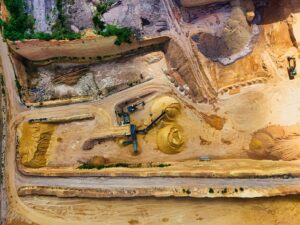 Aerial view of industrial sand extraction with heavy machinery in a large quarry