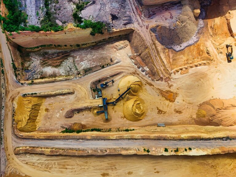 Aerial view of industrial sand extraction with heavy machinery in a large quarry