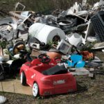 Pile of discarded household appliances and broken consumer products representing skimpflation and declining product durability