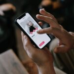 Person swiping through a dating app profile on a smartphone