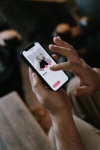 Person swiping through a dating app profile on a smartphone
