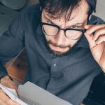 Tenant examining a rental document at home as rent pricing decisions are increasingly shaped by algorithms