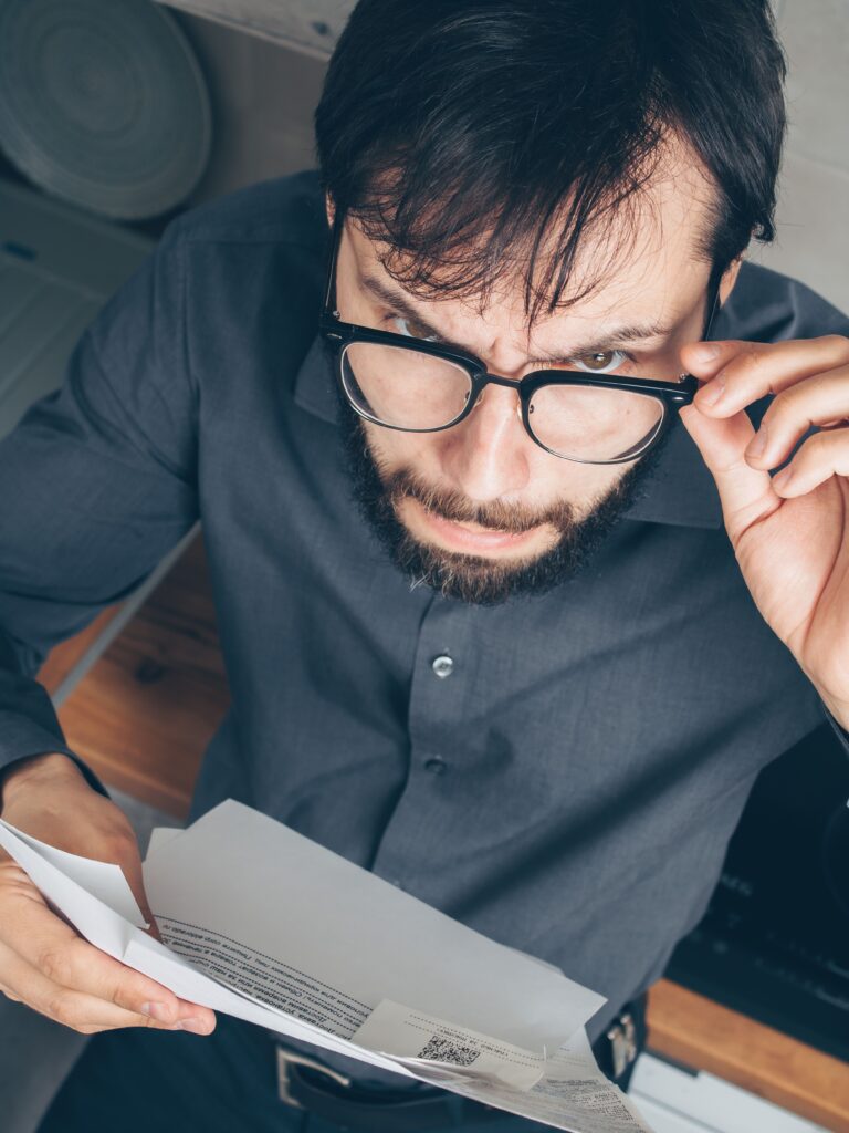 Tenant examining a rental document at home as rent pricing decisions are increasingly shaped by algorithms
