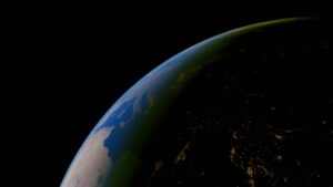 Earth seen from space at night with illuminated areas along the planet's surface