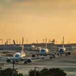 Multiple commercial airplanes taxiing at a busy airport as congestion and ground delays slow modern air travel