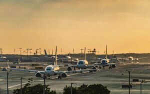 Multiple commercial airplanes taxiing at a busy airport as congestion and ground delays slow modern air travel