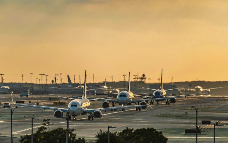 Multiple commercial airplanes taxiing at a busy airport as congestion and ground delays slow modern air travel