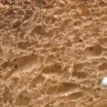 Extreme macro view of bread crumb and crust showing its porous cellular structure