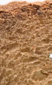 Extreme macro view of bread crumb and crust showing its porous cellular structure