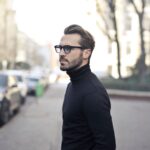 Man wearing black glasses on a city street, illustrating the future of everyday smart eyewear