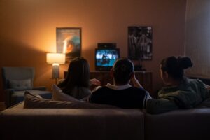 Three people watching television together in a dark living room