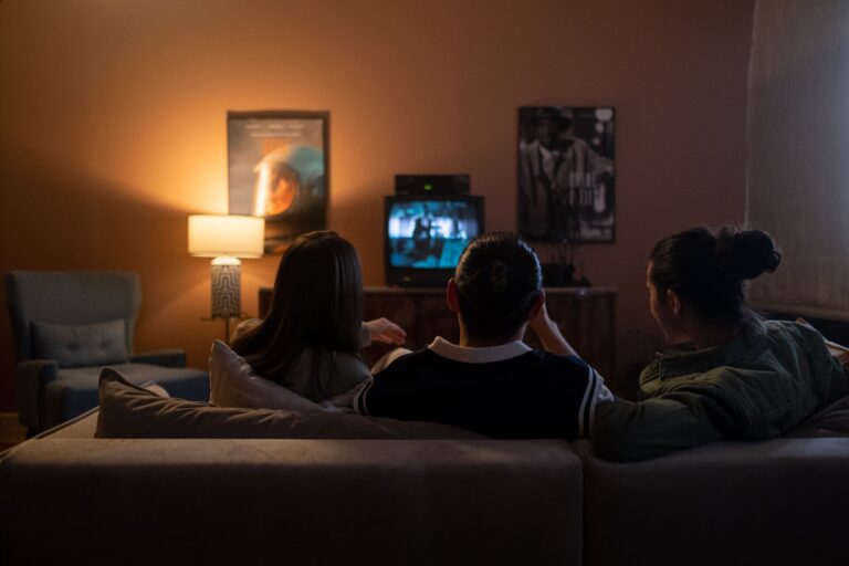 Three people watching television together in a dark living room