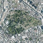 Aerial view of a large cemetery surrounded by dense urban development and major roads