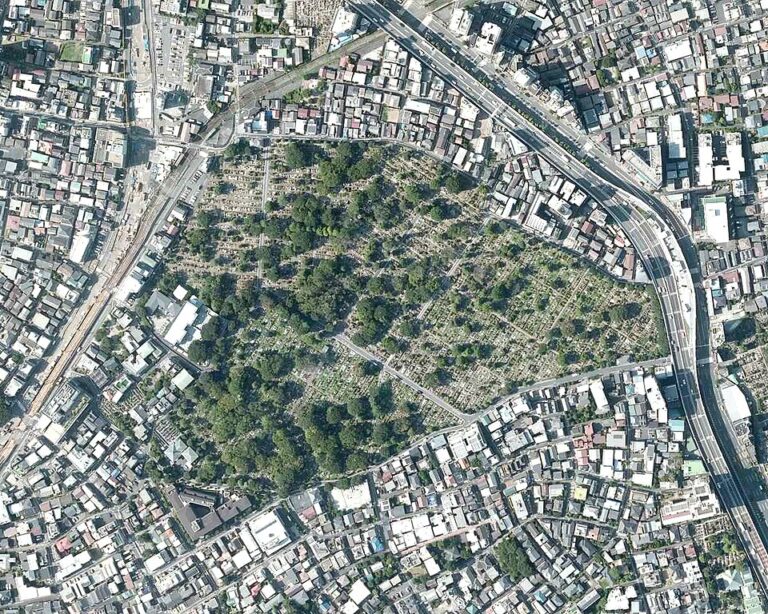 Aerial view of a large cemetery surrounded by dense urban development and major roads