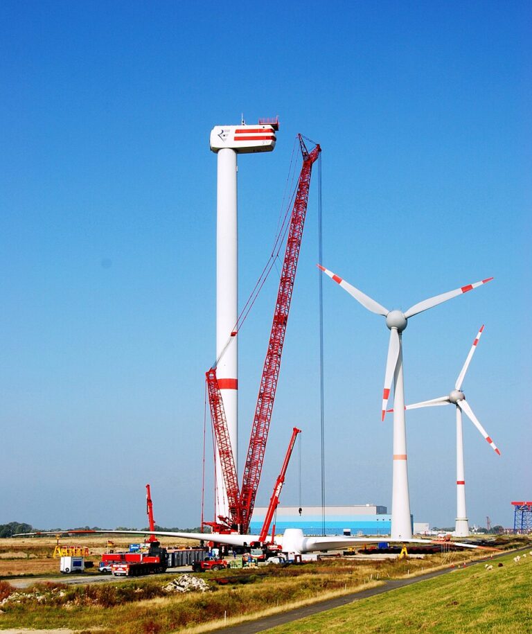 Wind turbine being dismantled during repowering as other turbines continue operating in the background