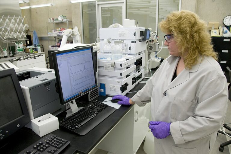 Scientist examining analytical results on laboratory equipment.