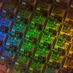 Close-up of a semiconductor die showing intricate microchip circuitry in vivid colours.