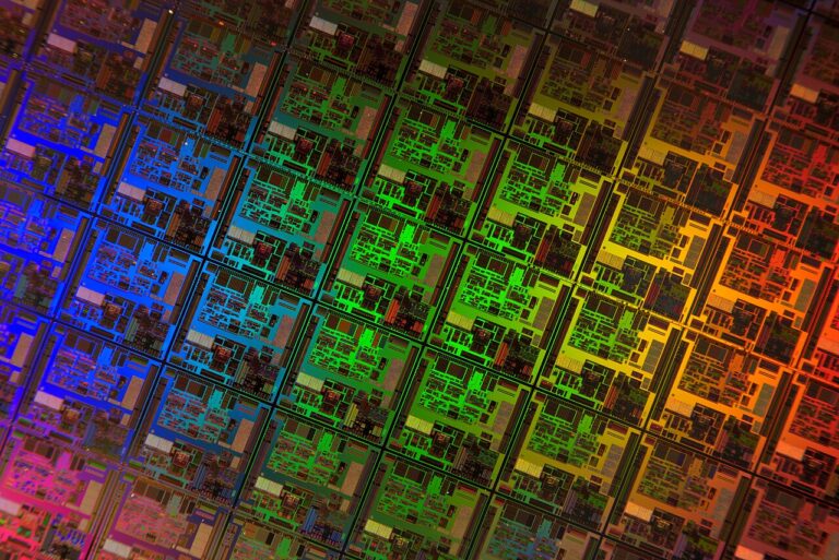 Close-up of a semiconductor die showing intricate microchip circuitry in vivid colours.