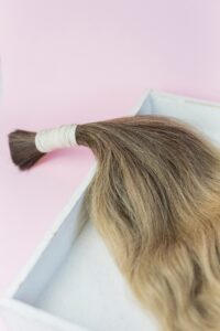 A tied bundle of human hair prepared for use in hair extensions.