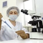 Embryologist working with laboratory equipment in a fertility research setting